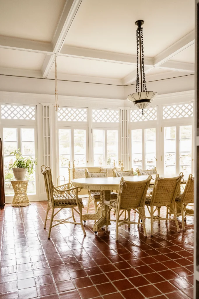 A dining room with lots of natural light from windows and a chandelier